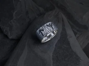 En maskulin runering i 925 sterling sølv med en rustik overflade og dybe runeindgraveringer, som hylder de nordiske guder Odin og Tyr.