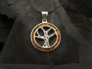 Vedhæng i ægte sølv med Yggdrasil – det nordiske livstræ – omgivet af en ring med indlagt rav, håndlavet af Nordic By Scharff.